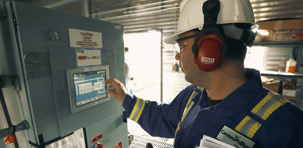 Sean Hiebert, ConocoPhillips Canada's Operations Efficiency Team Lead, showcasing a RemVue 500AS control panel.